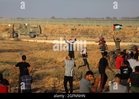 Gaza-Streifen. August 2021. Palästinensische Demonstranten laufen von Tränengas, das von israelischen Sicherheitskräften während eines Protestes entlang des Grenzzauns östlich von Khan Yunis im südlichen Gazastreifen abgefeuert wurde, um die israelische Blockade des palästinensischen Sektors anzuprangern. Stockfoto