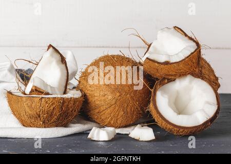 Haufen zerbrochener Kokosnüsse auf gerissenen grauen Hintergrund Stockfoto