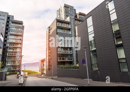 Leere Straße zwischen neuen Hochhäusern am Wasser bei Sonnenuntergang Stockfoto