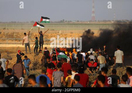 Gaza-Streifen. August 2021. Palästinensische Demonstranten laufen von Tränengas, das von israelischen Sicherheitskräften während eines Protestes entlang des Grenzzauns östlich von Khan Yunis im südlichen Gazastreifen abgefeuert wurde, um die israelische Blockade des palästinensischen Sektors anzuprangern. Stockfoto