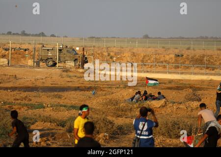 Gaza-Streifen. August 2021. Palästinensische Demonstranten laufen von Tränengas, das von israelischen Sicherheitskräften während eines Protestes entlang des Grenzzauns östlich von Khan Yunis im südlichen Gazastreifen abgefeuert wurde, um die israelische Blockade des palästinensischen Sektors anzuprangern. Stockfoto