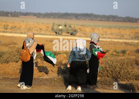 Gaza-Streifen. August 2021. Palästinensische Demonstranten laufen von Tränengas, das von israelischen Sicherheitskräften während eines Protestes entlang des Grenzzauns östlich von Khan Yunis im südlichen Gazastreifen abgefeuert wurde, um die israelische Blockade des palästinensischen Sektors anzuprangern. Stockfoto