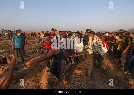 Gaza-Streifen. August 2021. Palästinensische Demonstranten laufen von Tränengas, das von israelischen Sicherheitskräften während eines Protestes entlang des Grenzzauns östlich von Khan Yunis im südlichen Gazastreifen abgefeuert wurde, um die israelische Blockade des palästinensischen Sektors anzuprangern. Stockfoto