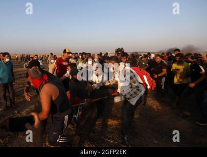 Gaza-Streifen. August 2021. Palästinensische Demonstranten laufen von Tränengas, das von israelischen Sicherheitskräften während eines Protestes entlang des Grenzzauns östlich von Khan Yunis im südlichen Gazastreifen abgefeuert wurde, um die israelische Blockade des palästinensischen Sektors anzuprangern. Stockfoto