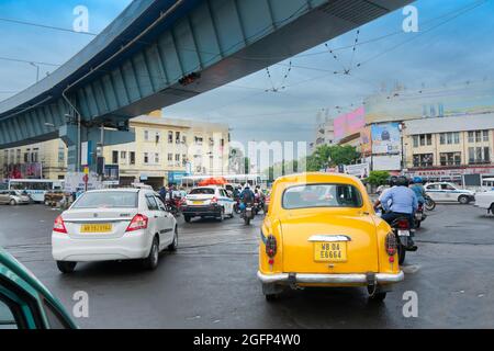 Kolkata, Westbengalen, Indien - 6. August 2019 : Gelbes Taxi, das unter der AJC Bose-Straßenüberführung vorbeifährt, geschäftiges Stadtleben auf der Kolkata-Straße. Stockfoto