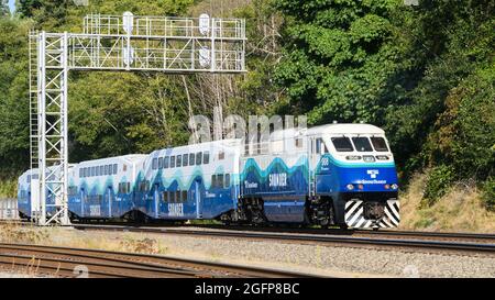 Mukilteo, WA, USA - 23. August 2021; EIN nordwärts fahrender Sound Transit Sounder-Pendlerzug fährt nördlich von Mukilteo unter einer Signalbrücke durch Stockfoto