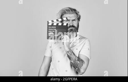 Lieblingsserie. Aktion. Kinoproduktion. Kreativer Produzent. Bärtiger Mann hält Filmklapper. Filmkonzept. Klapperboard-Kopierraum. Sehen Sie Stockfoto