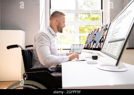 Behinderter Fachmann Im Rollstuhl, Der An Der Computerkodierung Arbeitet Stockfoto