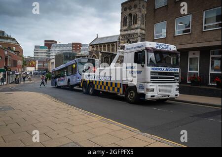 Schwerer Bergewagen, der einen zerbrochenen Eindeckerbus in Norwich City schleppt Stockfoto