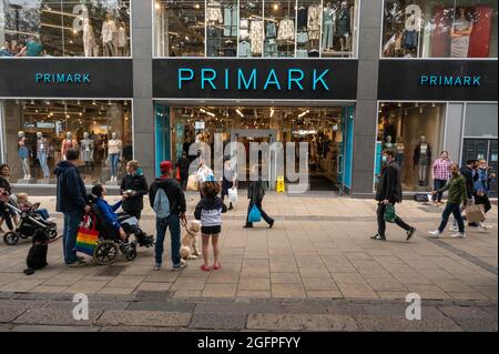 Primark Fashion Store in Norwich mit Einkäufern, die das Gebäude mit Taschen verlassen Stockfoto