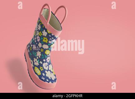 Isolierte Kinder Kleinkind regen Gummistiefel auf einem rosa Hintergrund 3d-Blickwinkel Stockfoto