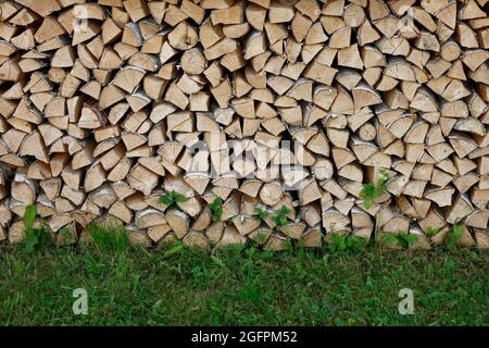 Gestapeltenes Brennholz in einem Feuer, Brennstoff für den Ofen und Kamin. Stockfoto