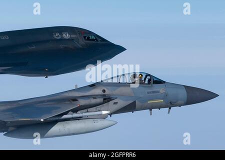 Nordsee, Großbritannien. August 2021. Ein F-15C Eagle-Kampfflugzeug der US Air Force, das dem 493rd Fighter Squadron zugewiesen wurde, fliegt während eines Trainings über der Nordsee am 25. August 2021 vor der Küste Schottlands an der Seite eines B-2 Spirit Stealth-Bombers. Quelle: Planetpix/Alamy Live News Stockfoto
