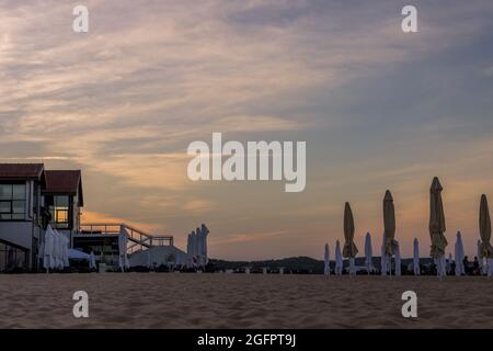 SOPOT, POLEN - 20. Jun 2021: Eine Aufnahme von geschlossenen Vordächern und einem Käfig an einem Sandstrand unter dem Sonnenuntergangshimmel in Sopot, Polen Stockfoto