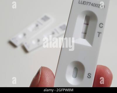 Sussex, Großbritannien, 26. August 2021: Ein positiver lateraler Durchflusstest zeigt eine deutliche Doppellinie, die das Vorhandensein des Coronavirus auf der Abstrichprobe bestätigt. Zwei negative laterale Durchflusstests zeigen nur eine einzige Linie bei C für die Steuerung. Mit über 38,000 neuen positiven Tests in den letzten 24 Stunden steigen die Covid-19-Fälle wieder an. Anna Watson/Alamy Live News Stockfoto