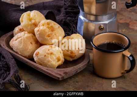 Tisch mit köstlichen Käsebrot, einem Kaffeebecher und einer traditionellen Kaffeemaschine. Stockfoto