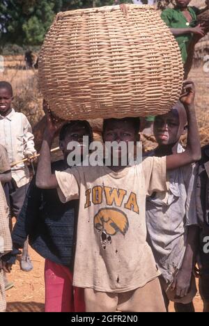Delaquara, ein Fulani-Dorf, Niger. Junger Junge, der Korb auf dem Kopf trägt. Stockfoto