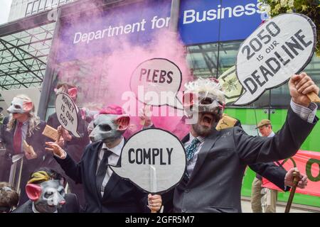 Demonstranten in Anzügen und Rattenmasken halten Plakate in Form von Sprechblasen mit den Slogans "Plebs", "Comply" und "2050 is our deadline" während der Demonstration vor dem Department for Business, Energy and Industrial Strategy.Extinction Rebellion Demonstranten marschierten vom Hyde Park zum Department for Business, Energie- und Industriestrategie als Teil ihrer zweiwöchigen Kampagne Impossible Rebellion, die die britische Regierung auffordert, in der Klima- und Umweltkrise sinnvoll zu handeln. (Foto von Vuk Valcic/SOPA Images/Sipa USA) Stockfoto