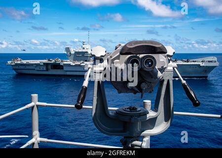 PHILIPPINISCHES MEER (Aug 24, 2021) das nach vorne eingesetzte amphibische Sturmschiff USS America (LHA 6) dampft neben dem Flugzeugträger der Royal Navy HMS Queen Elizabeth (R 08). Amerika, das Flaggschiff der America Expeditionary Strike Group, ist zusammen mit der 31. MEU im Verantwortungsbereich der 7. US-Flotte tätig, um die Interoperabilität mit Verbündeten und Partnern zu verbessern und als einsatzbereite Einsatztruppe für Frieden und Stabilität in der Indo-Pazifik-Region zu dienen. (USA Navy Foto von Mass Communication Specialist 3rd Class Matthew Cavenaile) Stockfoto