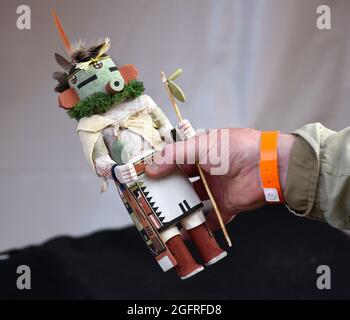 Ein Mann erwägt den Kauf einer zeitgenössischen Hopi-Kachina-Puppe von Edward Seechoma auf dem indischen Markt in Santa Fe, New Mexico. Stockfoto