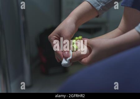 Hand mit Baumwolle und Aceton, um Gel zu entfernen lac auf den Füßen Zehen Nägel Unbekannte Frau, die Pediküre auf ihren Füßen zu Hause Nagellack Entfernen auf dem Fuß Finger Stockfoto