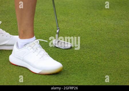 Minsk. Weißrussland - 25.07.2021 - Niederer Teil des Mannes, der Golf auf der Driving Range auf dem grünen Feld spielt Stockfoto