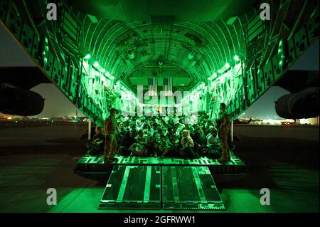 Eine US-Luftwaffe, die der 816. Expeditionary Airlift Squadron zugewiesen wurde, unterstützt qualifizierte Evakuierte an Bord eines C-17 Globemaster III-Flugzeugs der US-Luftwaffe zur Unterstützung der Evakuierung in Afghanistan am Hamid Karzai International Airport, Afghanistan, 21. August 2021. Das Verteidigungsministerium hat sich verpflichtet, das US-Außenministerium beim Ausscheiden von US-amerikanischem und alliiertem Zivilpersonal aus Afghanistan zu unterstützen und die afghanischen Verbündeten in Sicherheit zu bringen. (USA Air Force Foto von Senior Airman Taylor Coll über American Photoarchive/Alamy) Stockfoto