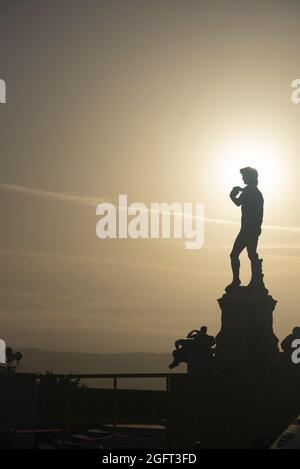 Vertikale Aufnahme der Silhouette der David-Statue vor einem Sonnenuntergangshimmel in Florenz, Toskana, Italien Stockfoto