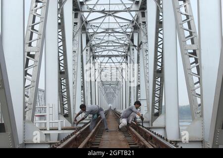 Die Brücke der Indian Railways in Bihar und Eisenbahner, die auf der Strecke arbeiten. Stockfoto