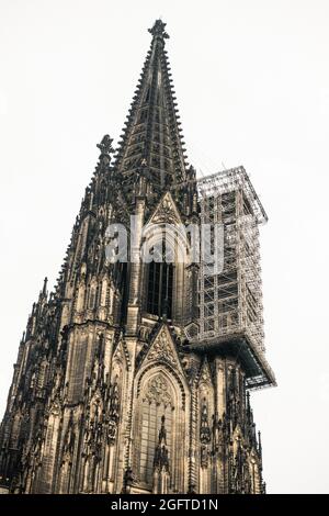 Vertikale Aufnahme des Höhepunkts des Kölner Doms im gotischen Stil mit einem Teil, der in Deutschland im Bau ist Stockfoto