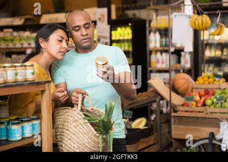 Ehepaar, das sich für Konserven im Supermarkt entschieden hat Stockfoto