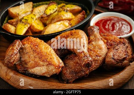 Gebratenes Huhn mit Kartoffeln und rote Sauce Stockfoto