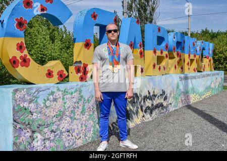 Slawjansk, Ukraine. August 2021. Der Paralympische Meister des ukrainischen Schwimmteams, Oleksandr Maschtschenko, wird während der Fotosession am Eingang nach Slawjansk mit seinen Medaillen gesehen. (Foto von Andriy Andriyenko/SOPA Images/Sipa USA) Quelle: SIPA USA/Alamy Live News Stockfoto