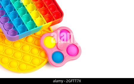 Pop IT Simple Dimple - Silikon sensorische Anti-Stress Fidget Spielzeug bunte Regenbogen-Spiel auf weißem Hintergrund isoliert, kopieren Raum. Stockfoto