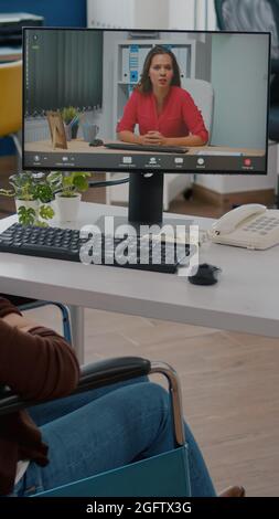 Ungültige behinderte immobilisierte Unternehmer im Gespräch mit Remote-Mitarbeiter während der Videokonferenz, Online-Meeting, Videocall im Rollstuhl sitzen arbeiten von Business-Office-Planung Finanzstrategie Stockfoto