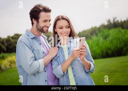 Foto von lächelnd fröhlich schönes hübsches Paar Entspannung im Freien mit Smartphone Surfen im Internet genießen Wochenende Stockfoto