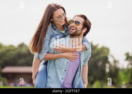 Foto von gute Laune positive schöne niedliche Paar Spaß im Freien Ehemann halten Frau Huckepack Herumduscht Stockfoto