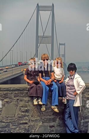 Archiv 1994 Ansicht der jungen 1990er-Familie von zwei Jungen und einem Mädchen mit Mama posiert vor der Autobahnaufhängung M4, die den Fluss Severn überquert und eine Pause an der ursprünglichen Autobahnzufahrt Aust einschlägt Ein Wohnmobil Reise nach Wales an einem hellen sonnigen Tag erfordert das Tragen von Sonnenbrillen ein 90er Jahre Archivbild Von der Art, wie wir waren, als Vater das Foto in South Gloucestershire, England, machte Stockfoto