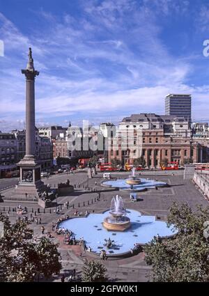 Historisches 1997Archiv Luftaufnahme mit Kopierraum Blick auf Touristen in den 1990er Jahren Trafalgar Square mit Brunnen und blauen Stein Becken neben Lord Nelsons Craigleith Sandsteinstatue auf einer korinthischen Säule aus Dartmoor-Granit zum Gedenken an Admiral Horatio Nelson, der bei der Schlacht von Trafalgar mit Canada House Beyond starb, wurde an einem sonnigen blauen Himmel der 90er Jahre gesehen Sommertag in City of Westminster London England Stockfoto