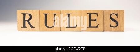 Das Wort Regeln wurde aus Holzwürfeln geschaffen. Gesetze und den Staat. Nahaufnahme. Stockfoto
