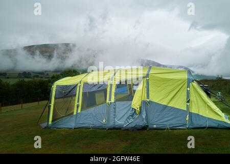 Zeltlager auf einem Farmfeld im Lake District gegenüber der Blencathra (Saddleback) fielen an einem bewölkten, nebligen Sommertag. Stockfoto