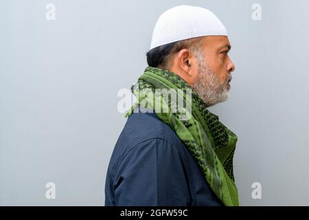 Porträt eines gutaussehenden bärtigen muslimischen Mannes an einer einfachen Wand Stockfoto