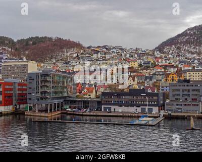 An einem winterlichen Tag im April haben sich Apartments, Häuser und Maritime Gebäude an der Küste des Hafens von Bergen vermischt. Stockfoto