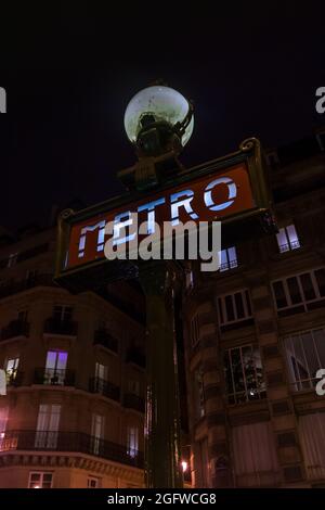 Traditionelles pariser Metro-Schild (U-Bahn, U-Bahn) mit altem, historischem Gebäude im Hintergrund in Paris. Stockfoto