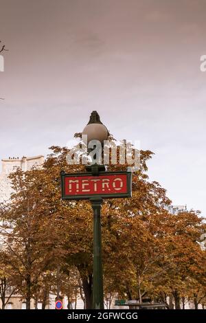 Traditionelles pariser Metro-Schild (U-Bahn, U-Bahn) mit altem, historischem Gebäude im Hintergrund in Paris. Stockfoto