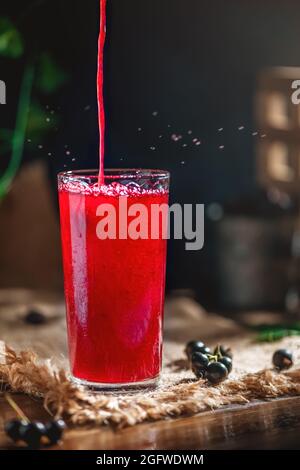 Der Fruchtsaft der Beeren im durchsichtigen Glas. Johannisbeere, Stachelbeere. Gesundes Getränk Stockfoto