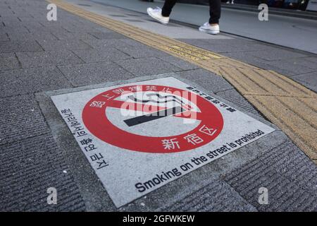 Tokio, Japan. August 2021. Eine Person geht an einem „Rauchverbot“-Schild auf einem Bürgersteig vorbei. Kredit: Marcus Brandt/dpa/Alamy Live Nachrichten Stockfoto