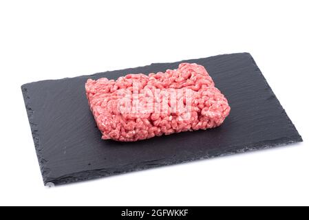 Hackfleisch auf schwarzem Schiefersteinbrett isoliert auf weißem Hintergrund. Speicherplatz kopieren. Stockfoto
