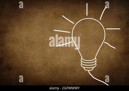 Eine weiße Lampe auf einem dunklen strukturierten Hintergrund, Symbol für Idee, Kreativität, Geschäft, Planung Stockfoto