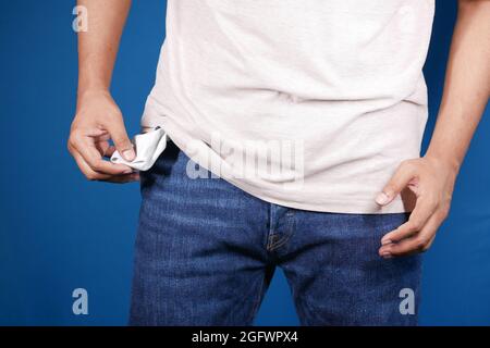 Der junge Mann zeigt eine leere Hosen-Tasche mit Kopieplatz Stockfoto